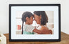 Close-up of the black 10-inch digital photo frame displaying a mother and daughter embracing. Shown as part of product listing for our 10-inch digital frame.